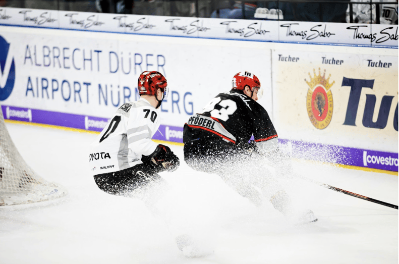 Two hockey players in action on the ice in front of a goal